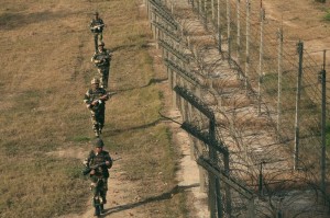 Indian BSF soldiers patrol near the fenced border with Pakistan in Suchetgarh