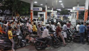 Motorcyclists crowd a fuel station to fill up on petrol in the western Indian city of Ahmedabad